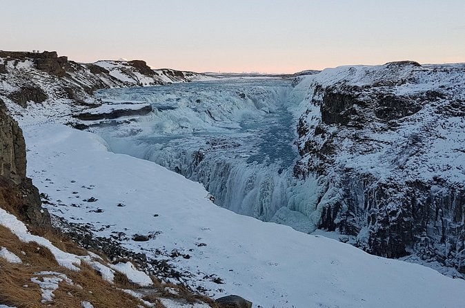 Gullfoss half frozen in winter, snow lying on both walls of the canyon