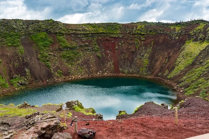 The red and green walls of Kerid crater around its turquoise lake
