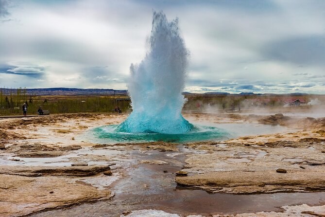 Strokkur throwing a turquoise column of water above the steaming geothermal field